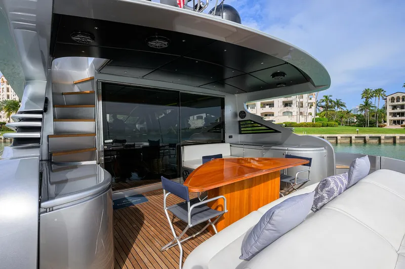 Slide: The Image of 2009 Pershing 90 Express yacht deck with seating and table, docked at marina. - 38