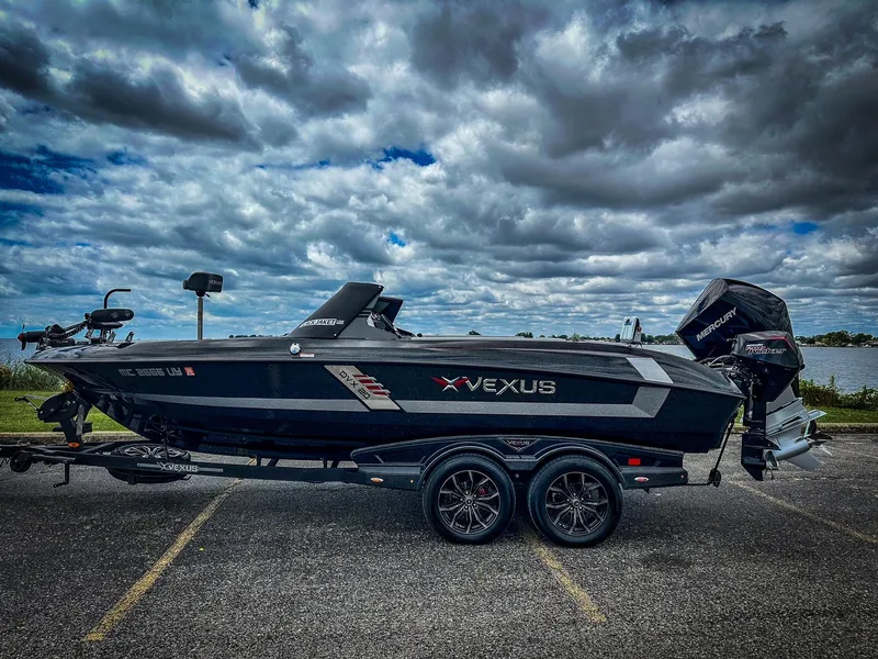 Slide: The Image of 2022 Vexus DVX20 boat on a trailer under a cloudy sky. - 0