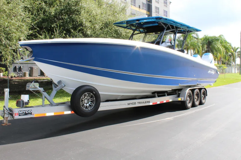 Slide: The Image of 2019 Nor-Tech 340 Sport Center Console boat on trailer, blue and white design. - 0
