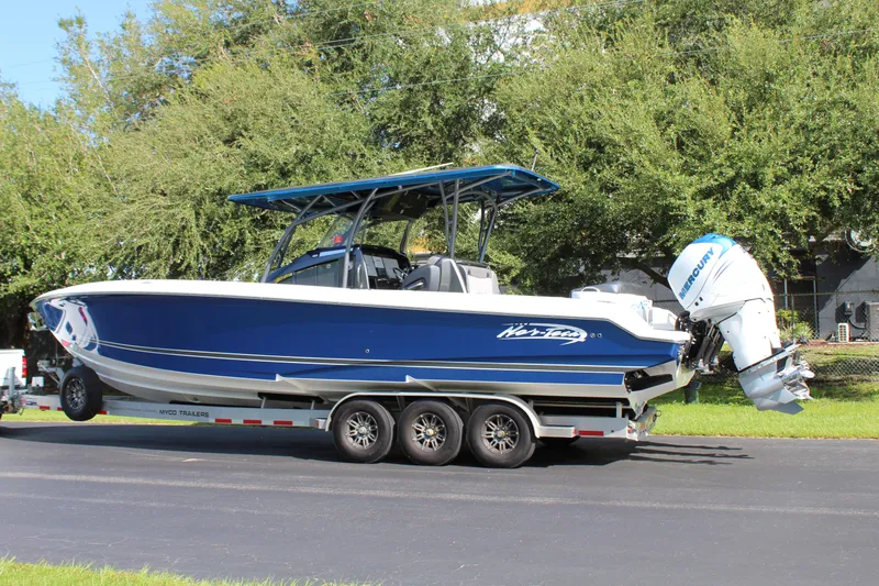 Slide: The Image of 2019 Nor-Tech 340 Sport Center Console boat on trailer, blue and white design. - 10