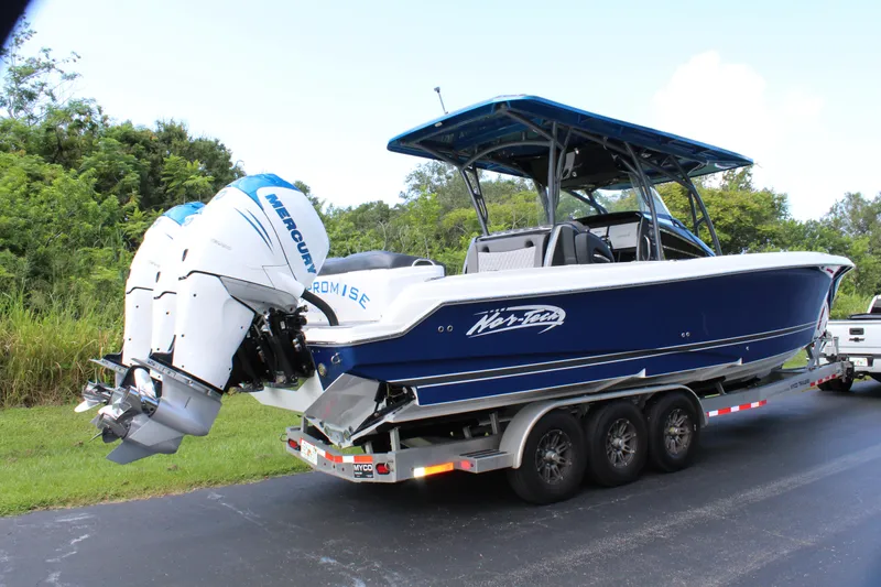 Slide: The Image of 2019 Nor-Tech 340 Sport Center Console boat on trailer, blue and white design. - 13