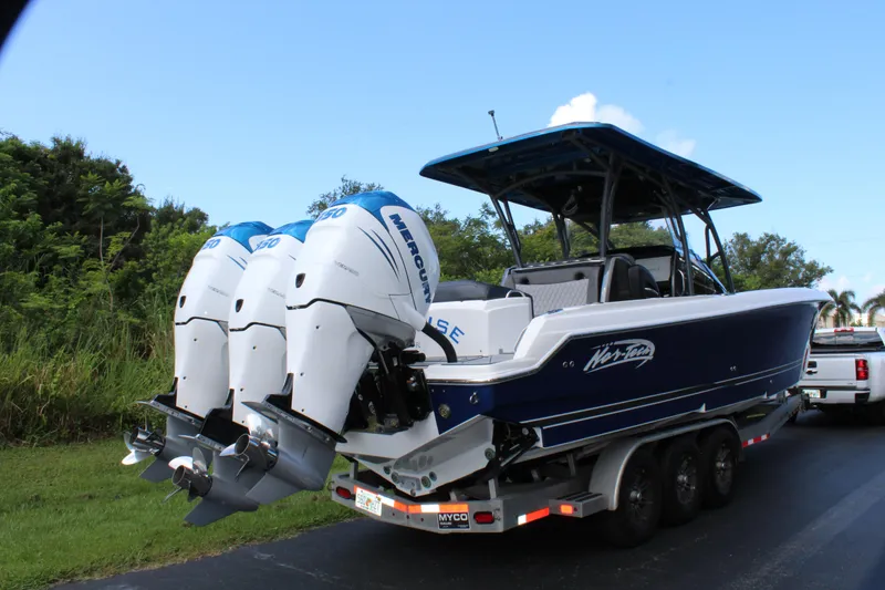 Slide: The Image of 2019 Nor-Tech 340 Sport Center Console boat with triple outboard engines on a trailer. - 16