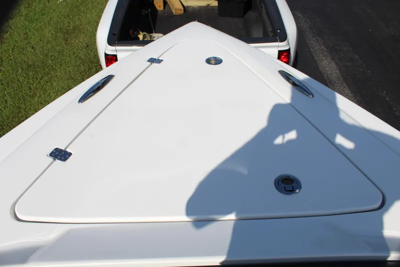 Slide: The Image of 2019 Nor-Tech 340 Sport Center Console boat bow, white finish, parked near a vehicle. - 47