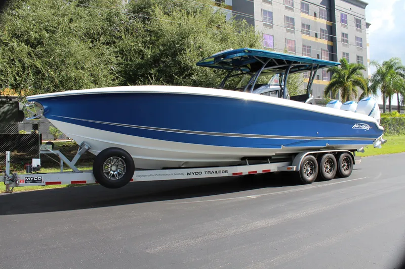 Slide: The Image of 2019 Nor-Tech 340 Sport Center Console boat on trailer, blue and white design. - 5