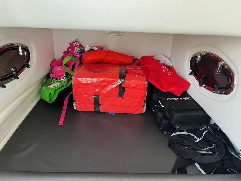 Slide: The Image of Storage compartment of a 2019 Nor-Tech 340 Sport Center Console boat with life jackets and gear. - 53