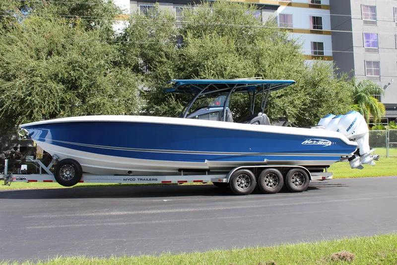 Slide: The Image of 2019 Nor-Tech 340 Sport Center Console boat on trailer, blue and white design. - 6