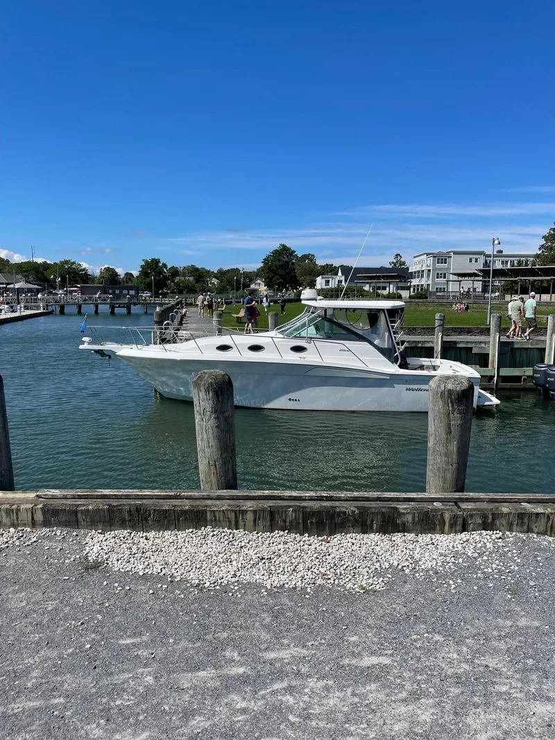 Slide: The Image of 2004 Wellcraft 330 Coastal boat docked at a marina on a sunny day. - 2