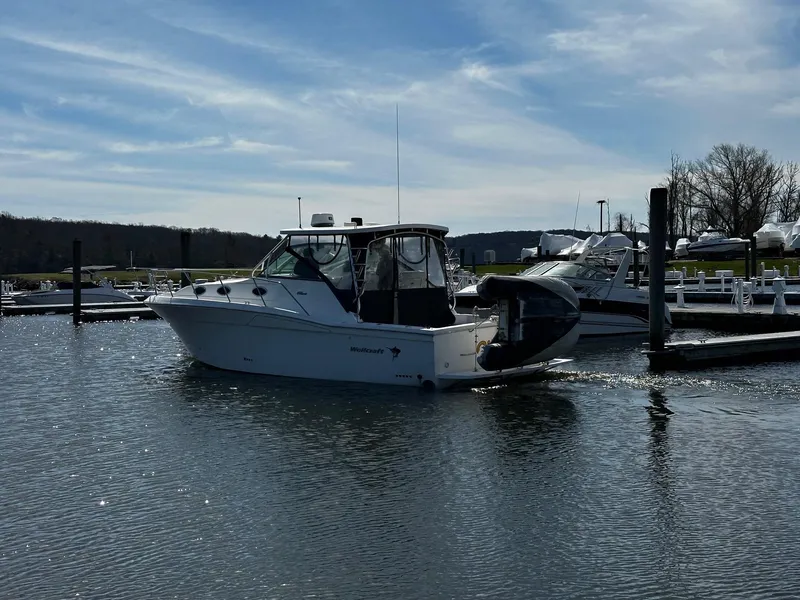 Slide: The Image of 2004 Wellcraft 330 Coastal boat docked in a marina under a clear blue sky. - 5