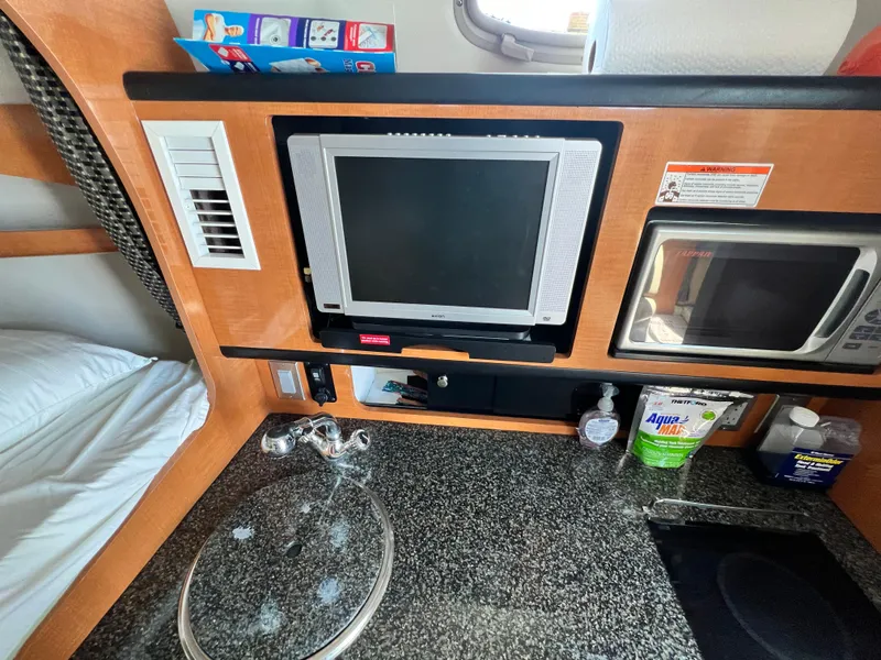 Slide: The Image of 2007 Chaparral Signature 280 interior with TV, microwave, and kitchenette. - 24