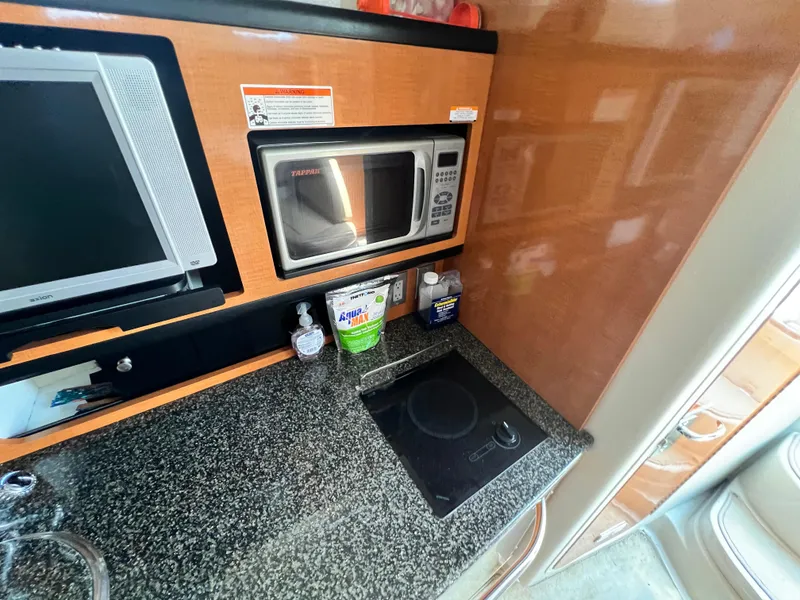 Slide: The Image of 2007 Chaparral Signature 280 kitchen area with microwave, TV, and countertop. - 25