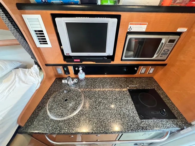 Slide: The Image of 2007 Chaparral Signature 280 galley with granite countertop, sink, stove, microwave, and TV. - 36