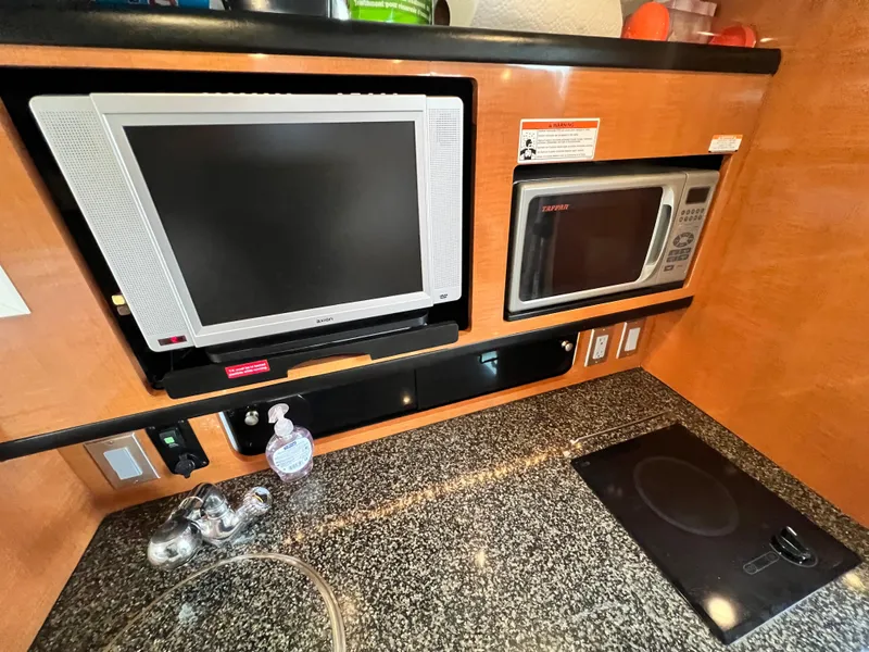 Slide: The Image of 2007 Chaparral Signature 280 galley with TV, microwave, and granite countertop. - 37