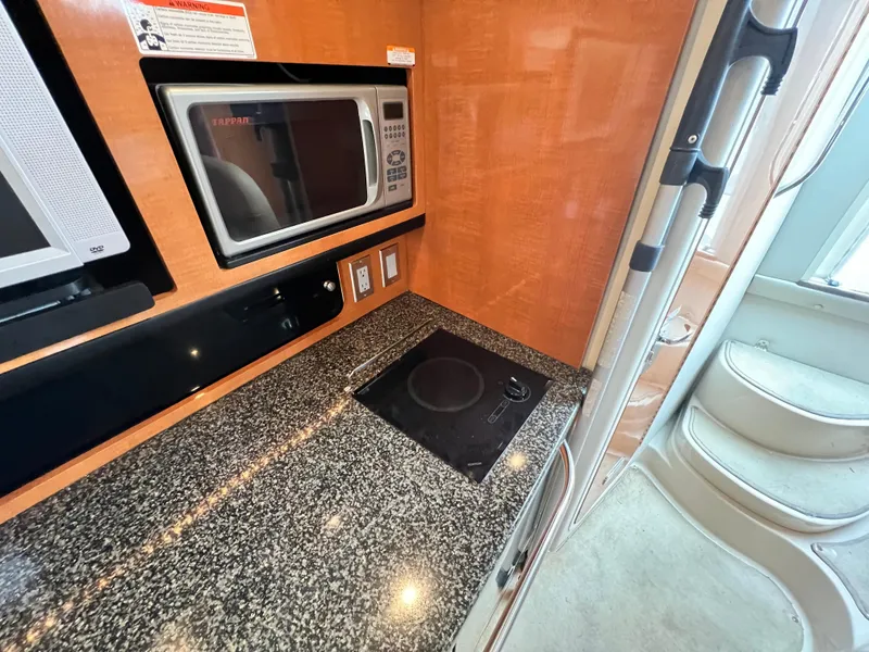 Slide: The Image of 2007 Chaparral Signature 280 galley with microwave, cooktop, and granite countertop. - 38