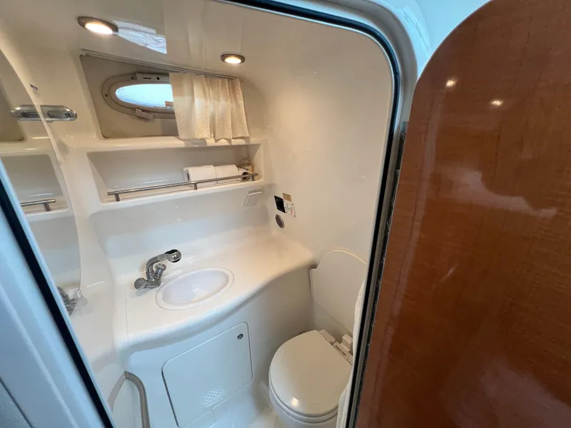 Slide: The Image of 2007 Chaparral Signature 280 boat bathroom with sink, toilet, and porthole window. - 44