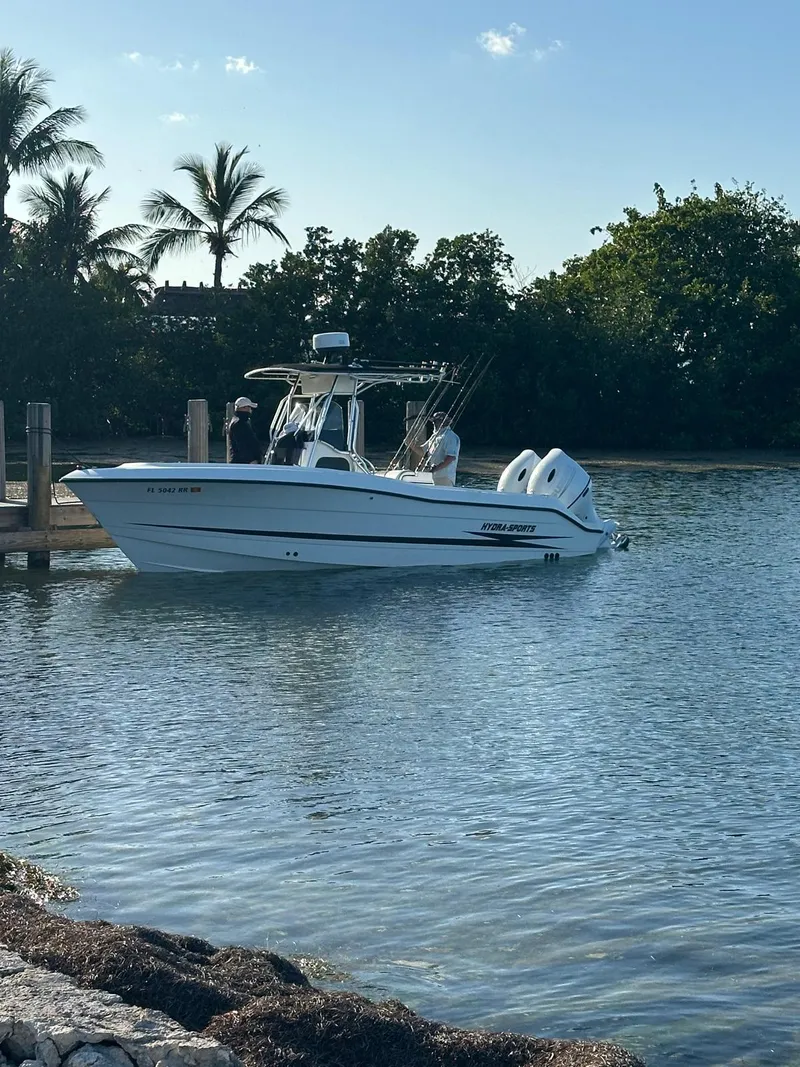 The Image of 2000 Hydra-Sports 2400 CC Vector boat docked in a serene tropical setting. - 1