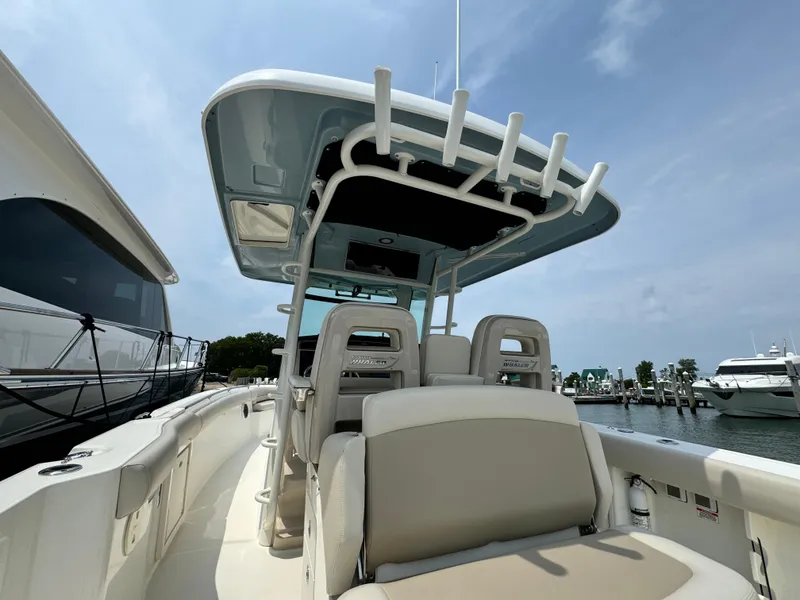 Slide: The Image of 2022 Boston Whaler 330 Outrage boat with seating and canopy, docked at marina. - 13