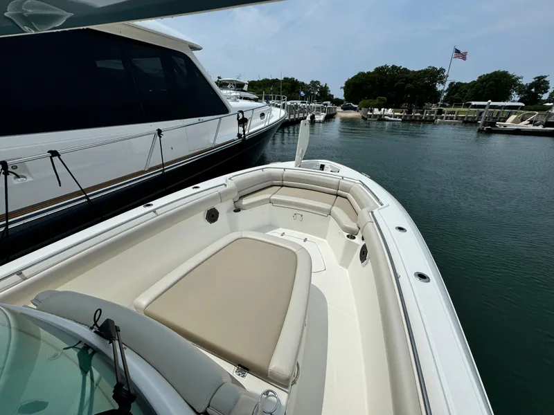 Slide: The Image of 2022 Boston Whaler 330 Outrage docked, showcasing spacious bow seating and sleek design. - 19