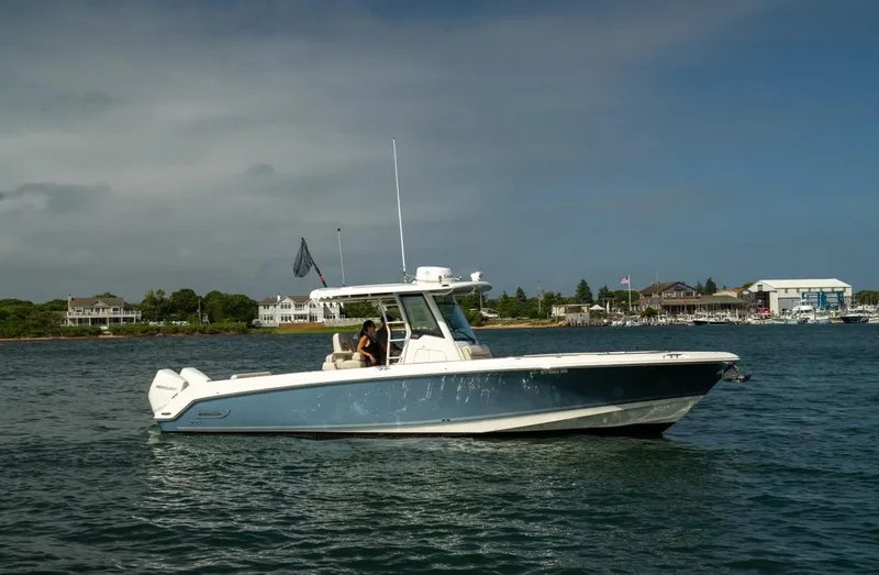 Slide: The Image of 2022 Boston Whaler 330 Outrage boat cruising on a calm waterway. - 2