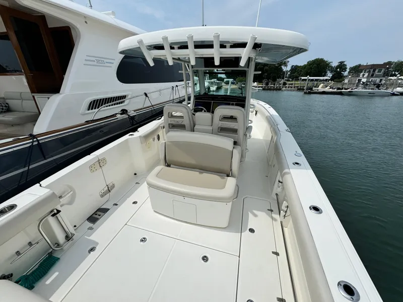 Slide: The Image of 2022 Boston Whaler 330 Outrage boat docked, featuring spacious seating and sleek design. - 8