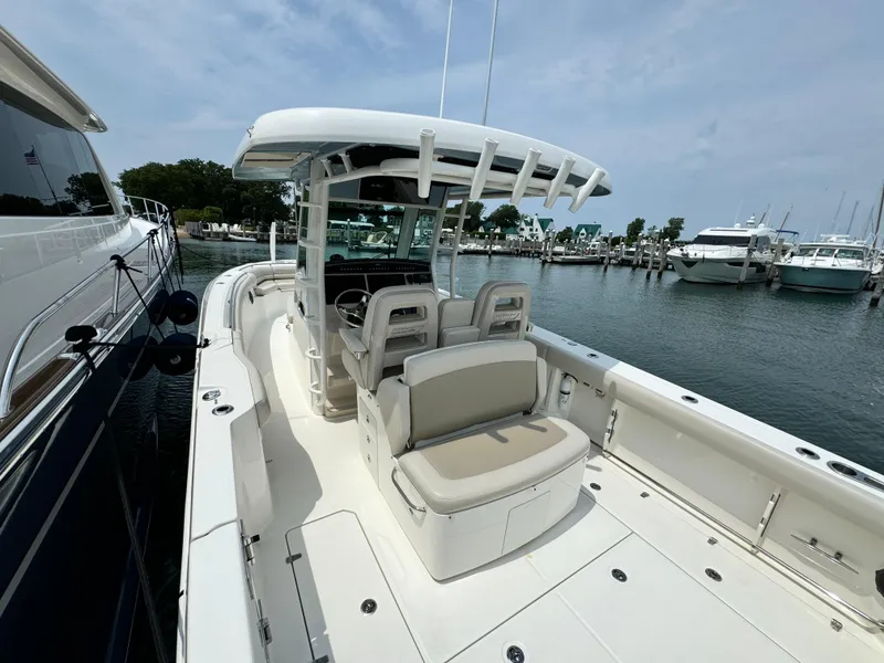 Slide: The Image of 2022 Boston Whaler 330 Outrage boat docked at marina, featuring spacious seating and sleek design. - 9