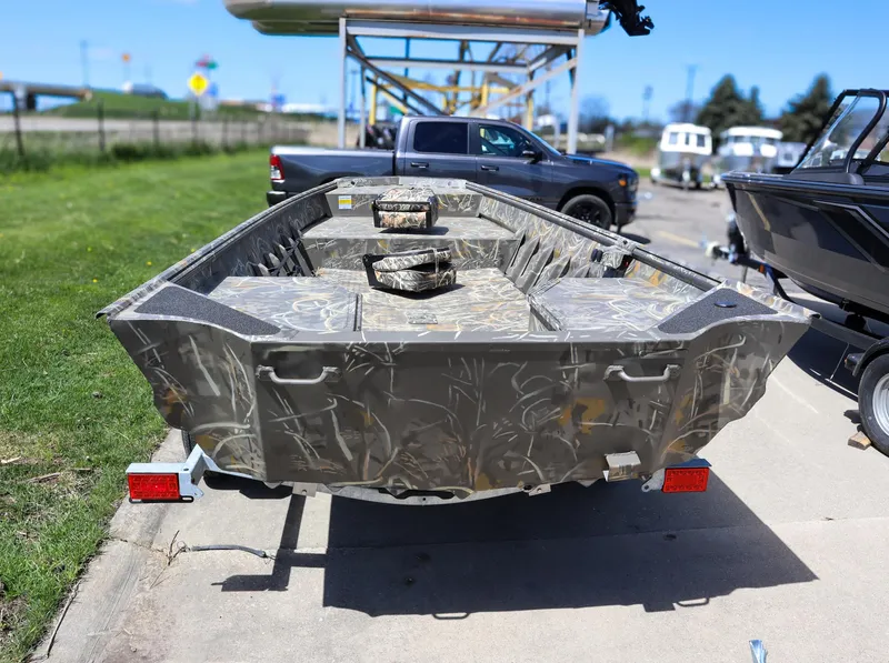 Slide: The Image of 2024 War Eagle 754LDV Sportsman boat on trailer, camo design, parked outdoors. - 5