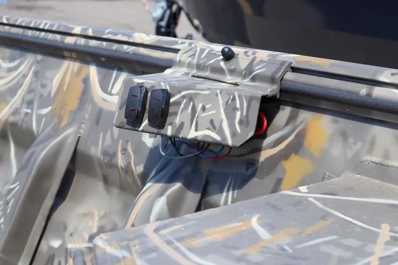 Slide: The Image of 2024 War Eagle 754LDV Sportsman boat with camouflage interior and control switches. - 9