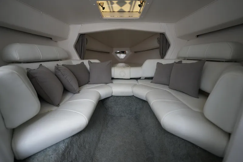 Slide: The Image of Luxurious interior of a 1999 Fountain 35 Lightning boat with white leather seating and gray pillows. - 17