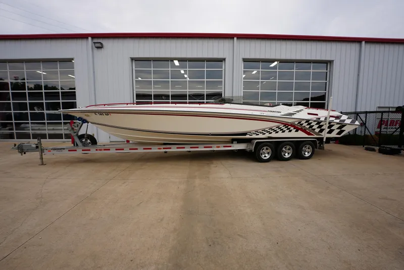 Slide: The Image of 1999 Fountain 35 Lightning speedboat on a trailer outside a garage. - 2
