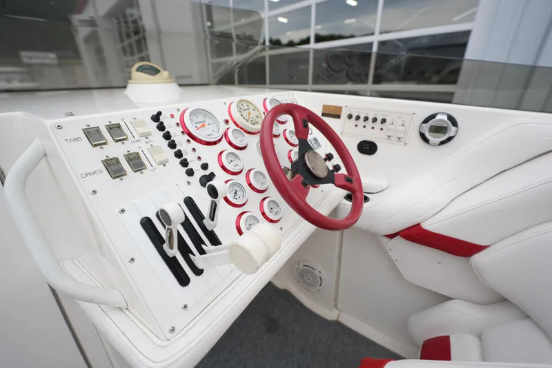 Slide: The Image of 1999 Fountain 35 Lightning boat dashboard with red steering wheel and control gauges. - 21