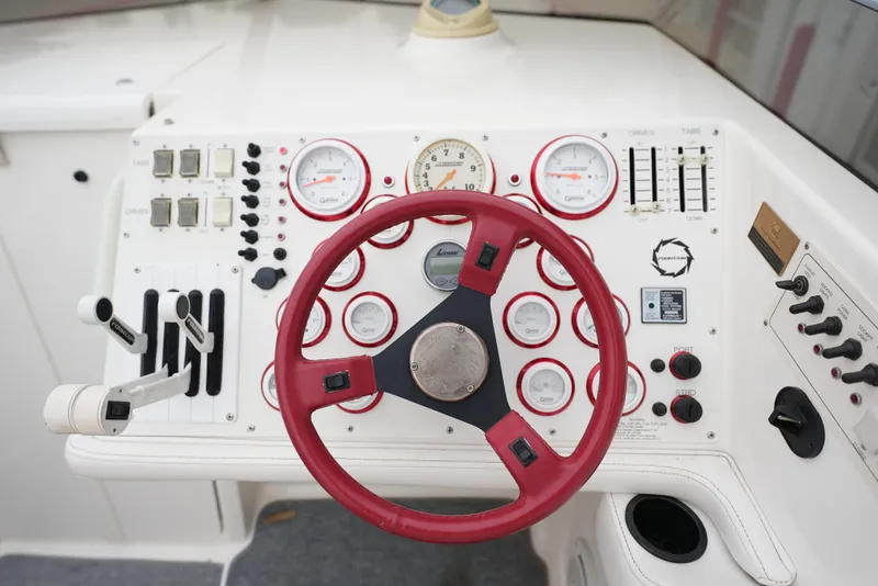 Slide: The Image of 1999 Fountain 35 Lightning boat dashboard with red steering wheel and control gauges. - 22