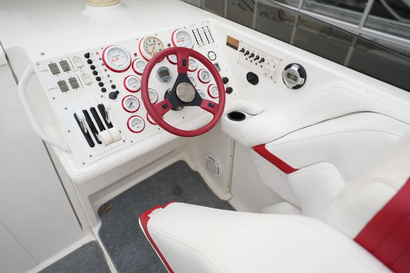 Slide: The Image of 1999 Fountain 35 Lightning boat cockpit with red and white steering wheel and gauges. - 23