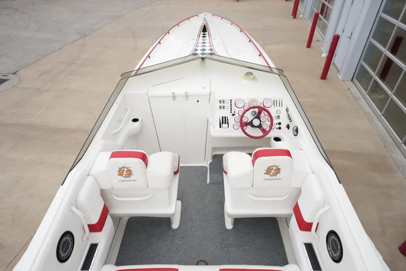 Slide: The Image of 1999 Fountain 35 Lightning boat interior with white and red seating, steering wheel, and dashboard. - 25