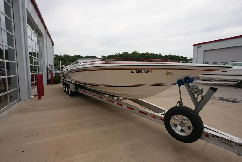 Slide: The Image of 1999 Fountain 35 Lightning boat on a trailer outside a garage. - 9