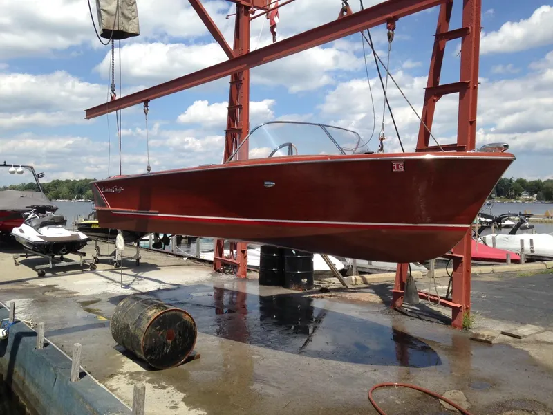 Slide: The Image of 1959 Chris-Craft 18 Continental boat suspended on a lift at a marina. - 8