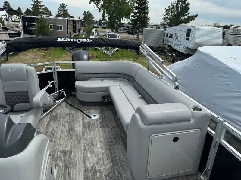 Slide: The Image of 2024 Ranger Reata 220C pontoon boat with gray seating and wood-style flooring. - 12