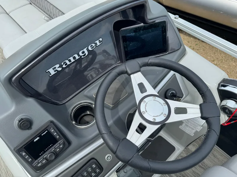 Slide: The Image of 2024 Ranger Reata 220C boat dashboard with steering wheel and electronic controls. - 19