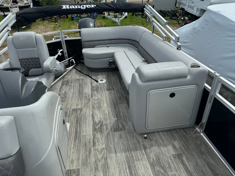 Slide: The Image of 2024 Ranger Reata 220C pontoon boat interior with gray seating and wood-like flooring. - 9