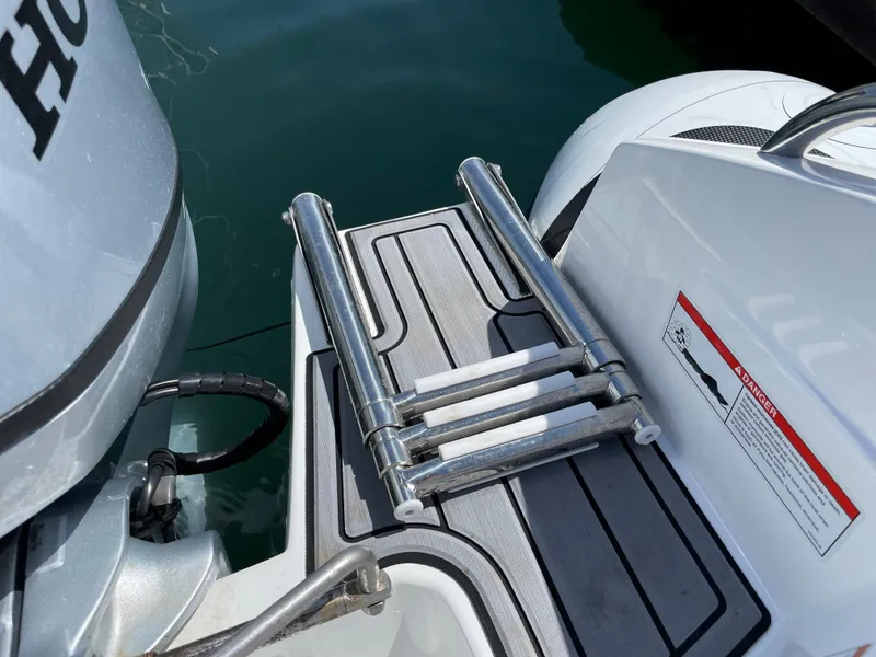 Slide: The Image of Walker Bay Venture 13 (2025) boat with a folded swim ladder and Honda outboard motor. - 9