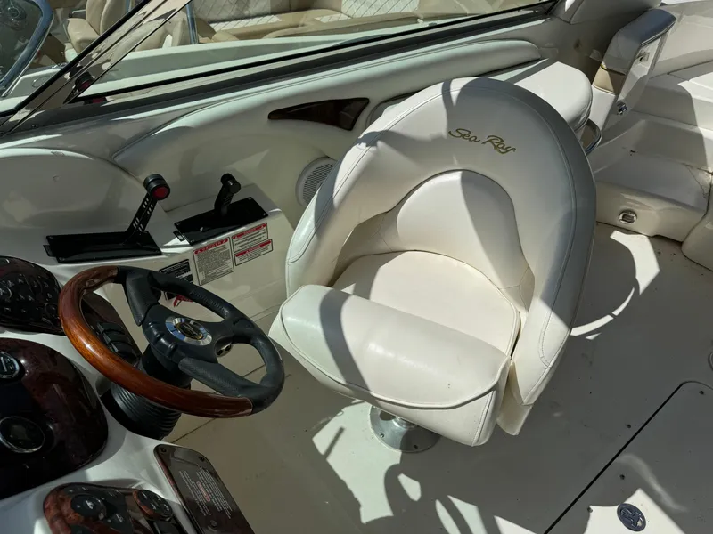 Slide: The Image of 2002 Sea Ray 290 Bow Rider cockpit with steering wheel and captain's chair. - 10