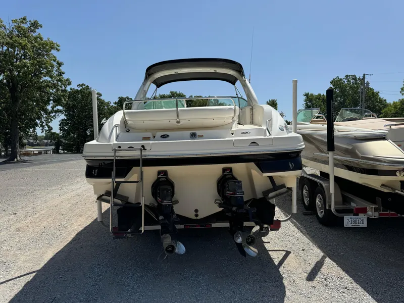 Slide: The Image of 2002 Sea Ray 290 Bow Rider boat, rear view, parked on gravel lot. - 3