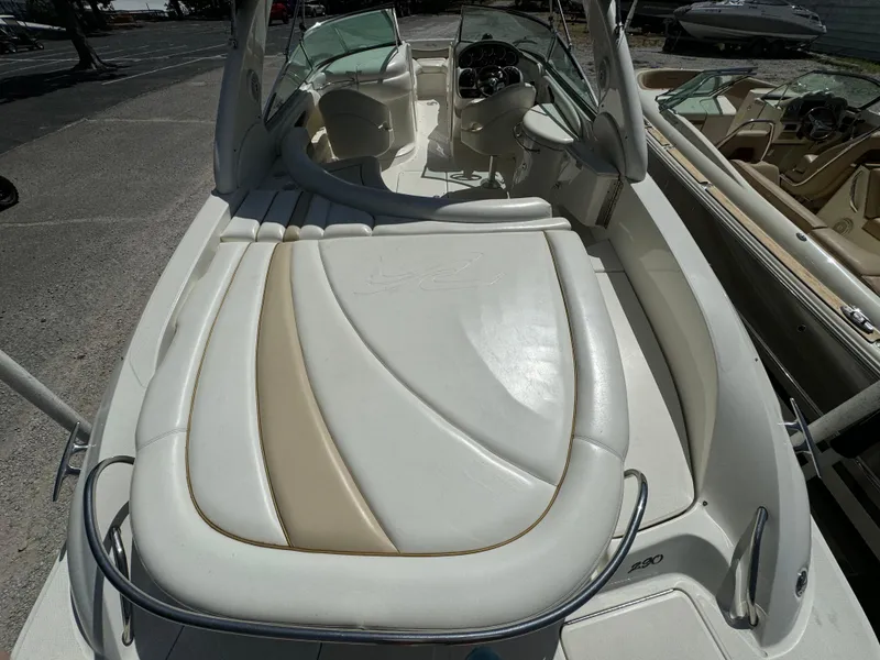 Slide: The Image of 2002 Sea Ray 290 Bow Rider boat interior with white and beige seating. - 4