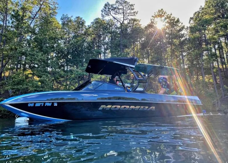 Slide: The Image of 2019 Moomba Craz boat on a lake with sun rays and forest background. - 1