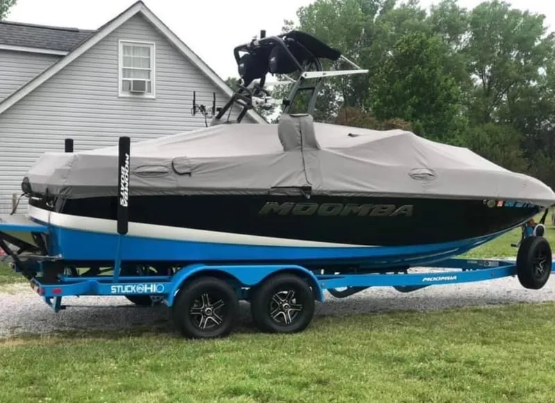 Slide: The Image of 2019 Moomba Craz boat on a blue trailer, covered and parked near a house. - 5