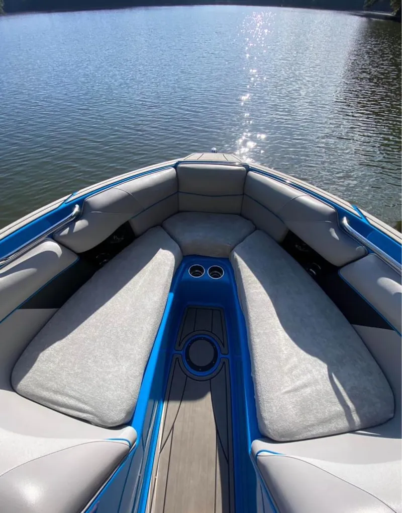 Slide: The Image of 2019 Moomba Craz boat interior with cushioned seating on a calm lake. - 9
