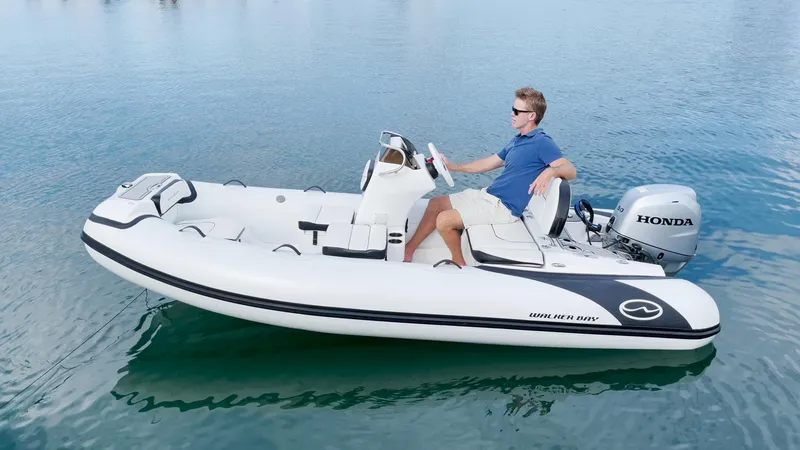 Slide: The Image of 2025 Walker Bay Generation 13 LTE boat on water with Honda outboard motor. - 9