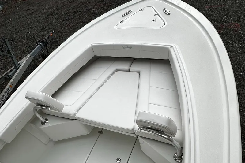 Slide: The Image of 2024 Pair Customs 21DV boat with white cushioned seating and storage compartments. - 6