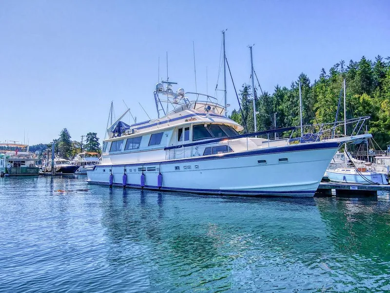 The Image of 1987 Hatteras 72 Flush Deck Cockpit Motor Yacht docked in a serene marina. - 0