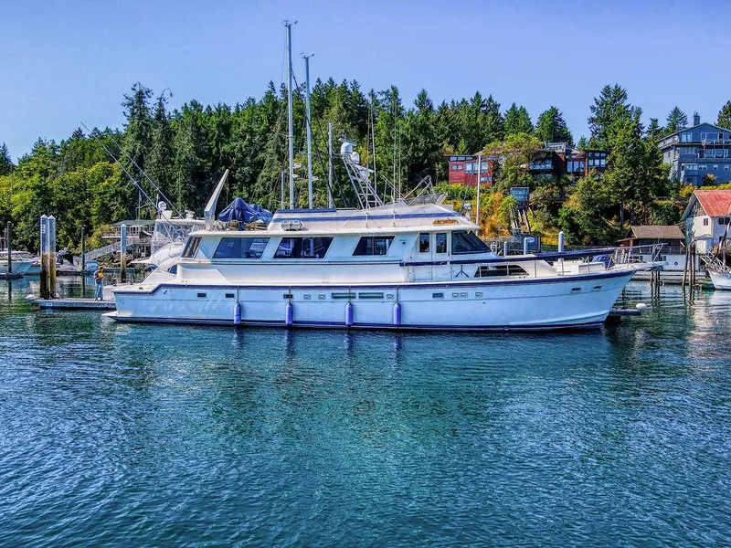 Slide: The Image of 1987 Hatteras 72 Flush Deck Cockpit Motor Yacht docked in scenic marina. - 1