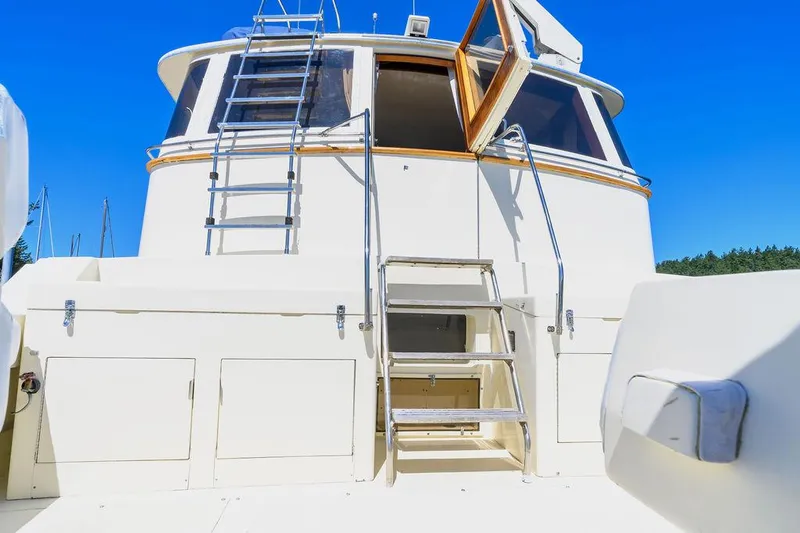 Slide: The Image of 1987 Hatteras 72 Flush Deck Cockpit Motor Yacht with ladder and open hatch under clear blue sky. - 11