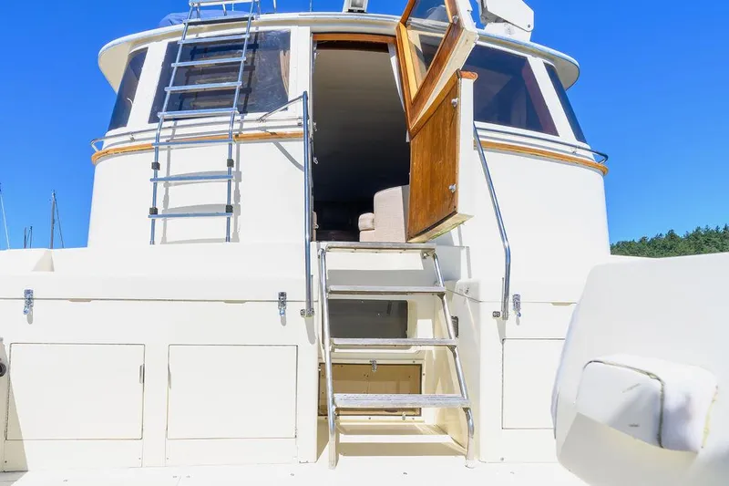 Slide: The Image of 1987 Hatteras 72 Flush Deck Cockpit Motor Yacht, rear view with open door and ladder. - 12